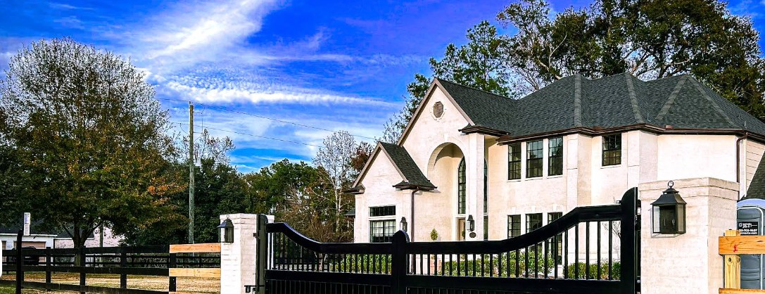 Custom black estate driveway gate with ranch rail fence — Gomez Fencing
